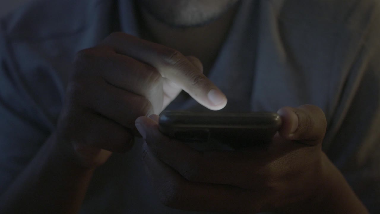 persona que utiliza un teléfono inteligente por la noche
