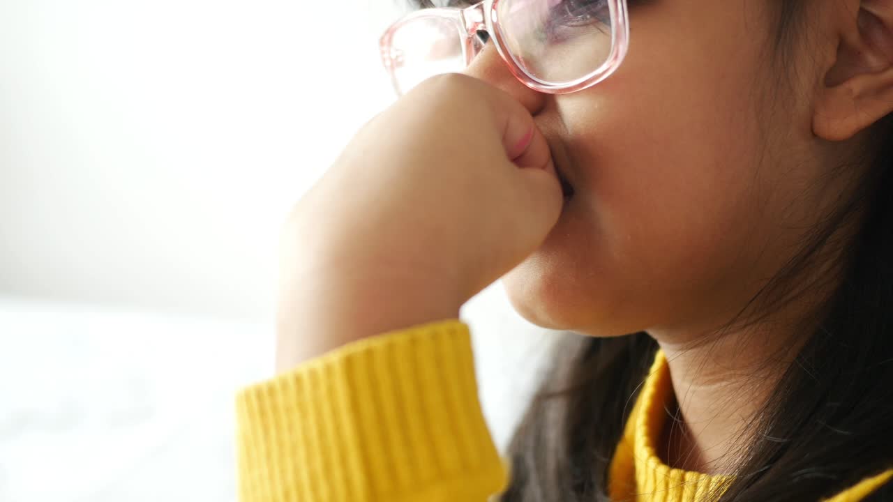 chica con gafas y dedo en la boca