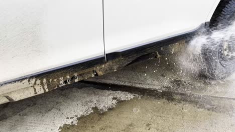 hosing down and spraying off tons of dry dirt and mud grime on a white overlanding suv with sprays of water
