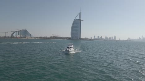 aerial view of yacht cruising against coast of dubai, united arab emirates