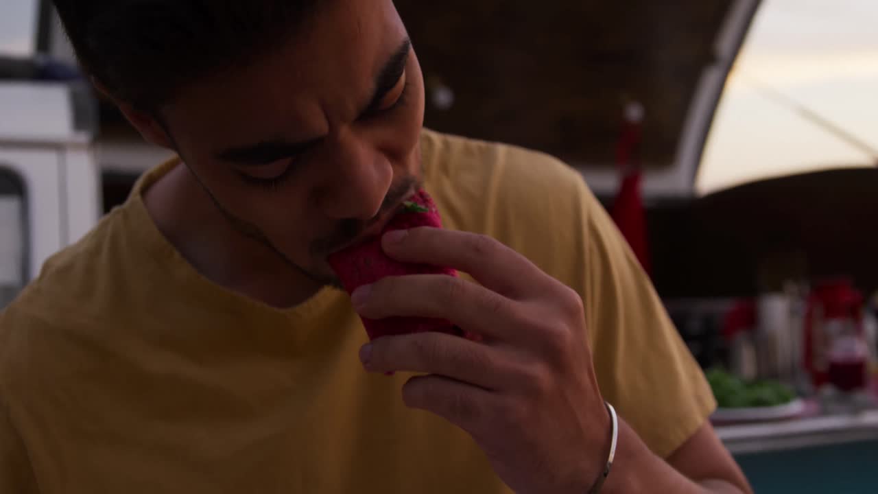 Jovem comendo um burrito do food truck