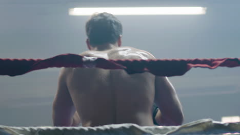 young male boxer doing shadow fight while training