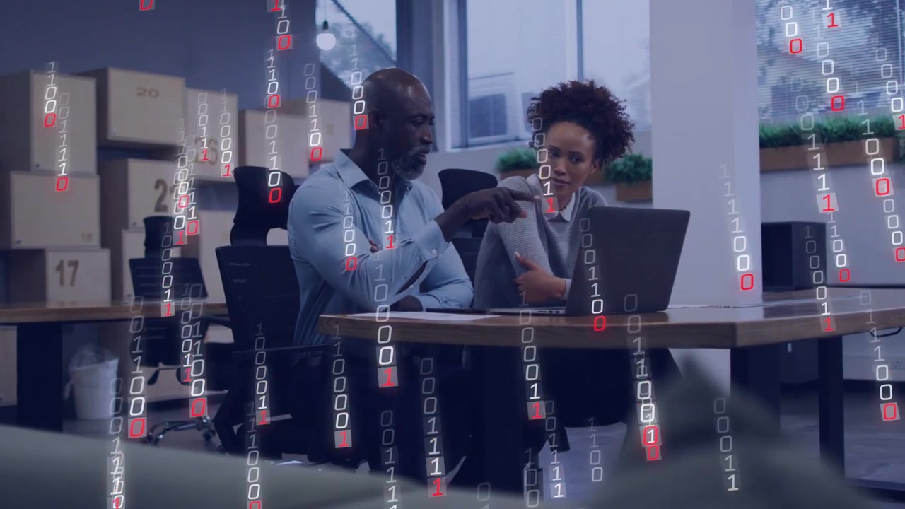 Mentor pointing at laptop, team member watching, binary overlay intensifying to show tech data