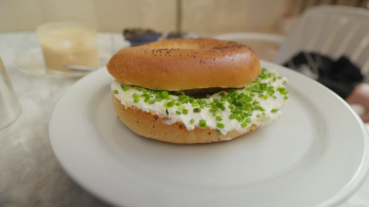 bagel fresco con queso con crema y cebolla en un plato blanco