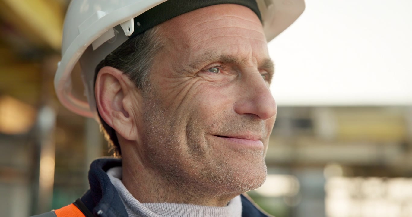 Mature Male Construction Worker Wearing Hard Hat Looking Away
