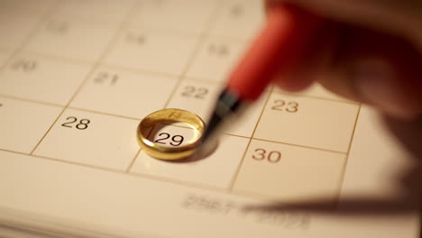 marking the date on a calendar for a wedding anniversary and drawing a heart shape on the day to remember it