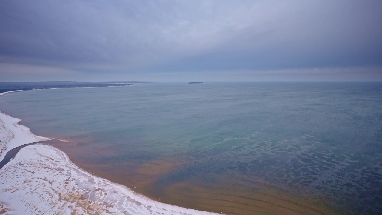 Cinematisk droneoptagelse af Lake Superiors kystlinje om vinteren med frossen kystlinje, iskolde bølger, snetækkede klipper, vildmarken i det nordlige Michigan, landskab fra De Store Søer og dramatisk vinterlandskab.