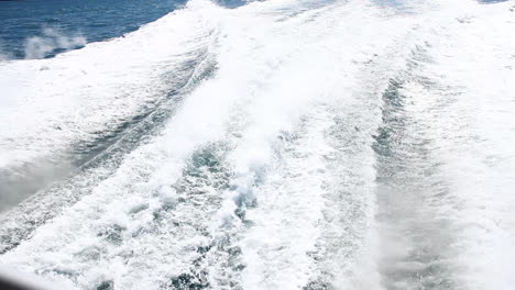 wake waves form behind boat on ocean