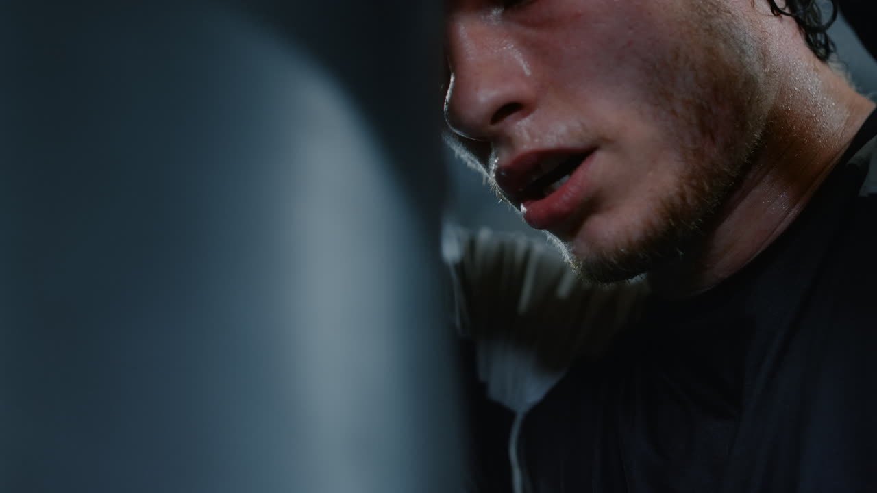 un luchador cansado teniendo un descanso en el ring. un deportista apoyado en una bolsa en un club deportivo.