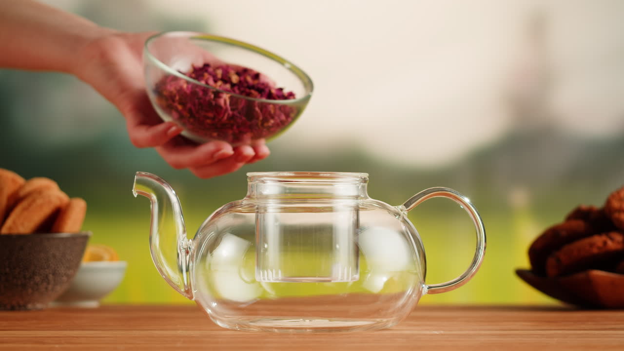 Preparing rose tea in a glass teapot