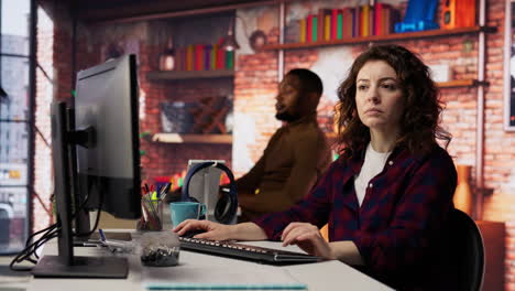 smiling woman using programming languages on pc in it startup office