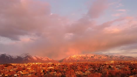 Disparo-De-Dron-En-La-Hora-Dorada-Del-Atardecer-De-Las-Montañas-Del-Norte-De-Utah-Mientras-El-Sol-Brilla-Sobre-Ellas,-Con-Hermosas-Nubes-Y-Cielo-De-Algodón-De-Azúcar