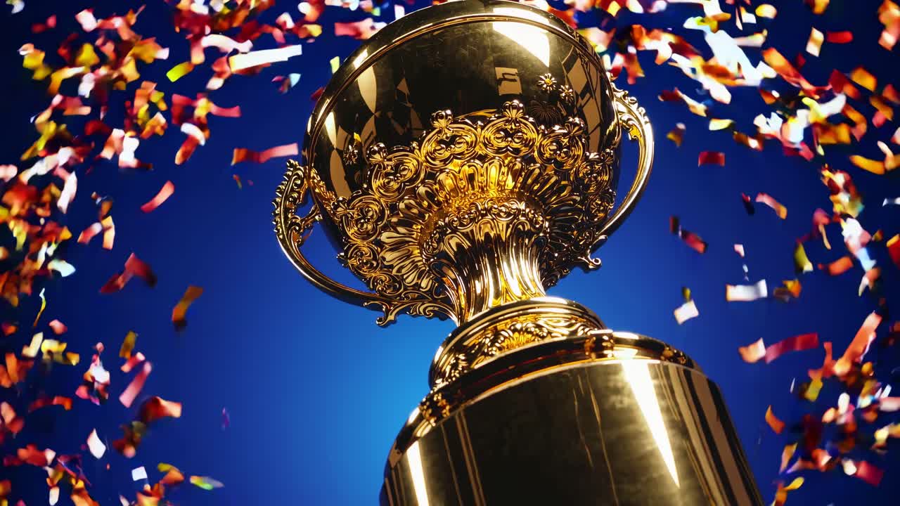 Inquadratura dal basso di un trofeo d'oro con coriandoli colorati che cadono, su uno sfondo blu