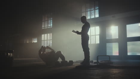 man doing crunches with a trainer