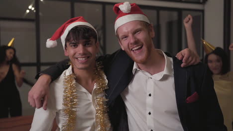 young excited men dancing looking at camera at new year's eve party