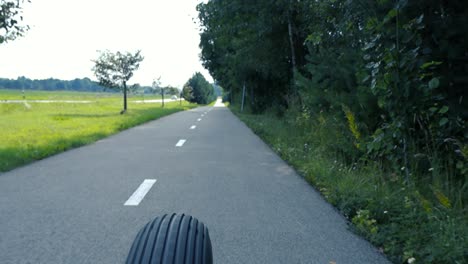 large chopper style bicycle vehicle driving on a cyclist road during the summer time in slow motion in point of view or first person view