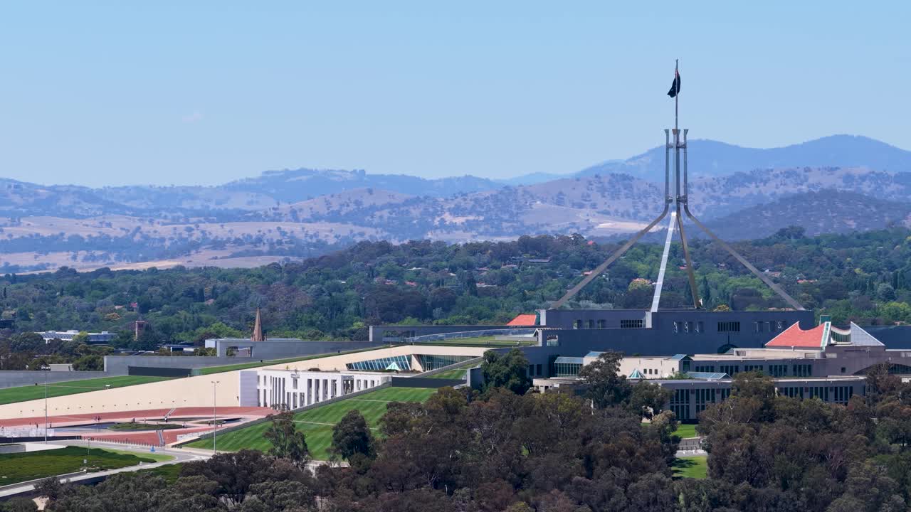 Una panorámica horizontal lenta capta la emblemática arquitectura de las Casas del Parlamento bajo un cielo azul despejado