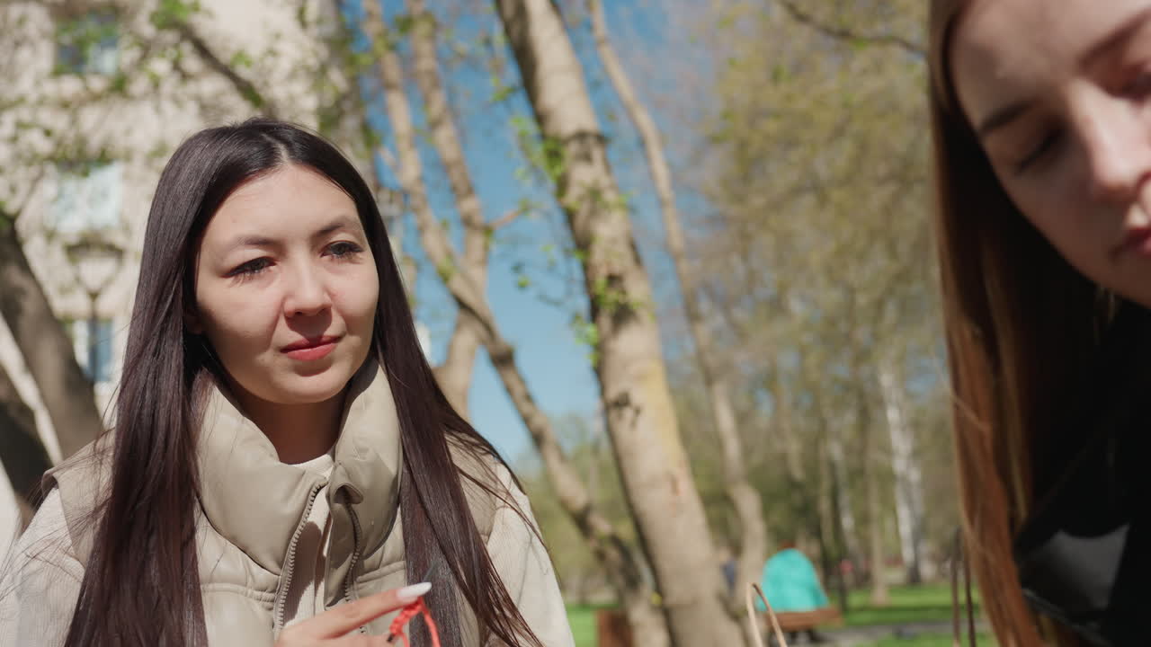 공원 환경에서 영상을 분석하는 친구들, 활짝 핀 나무 아래에서 콘텐츠를 논의하는 여성 그룹, 여유로운 봄날 공원 모임에서 태블릿으로 미디어를 검토하는 여성 팀