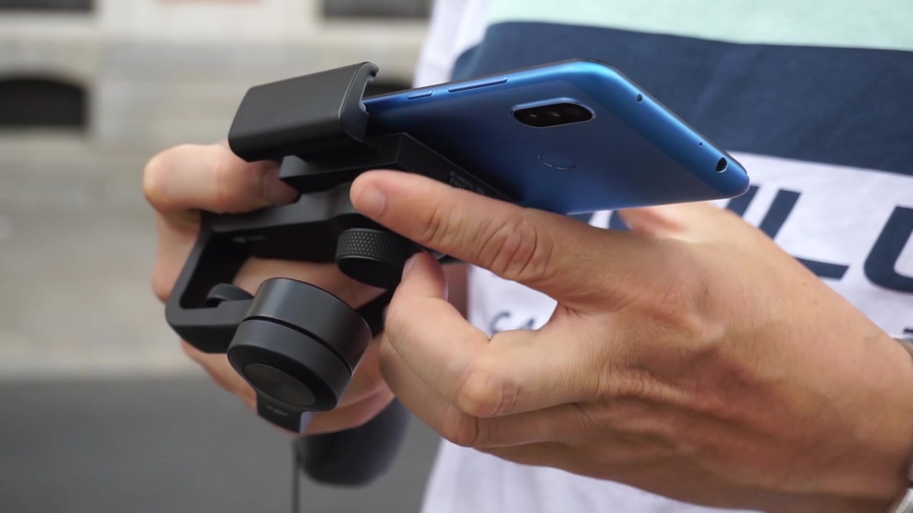 Nærbillede af mand, der sætter mobiltelefon i gimbal