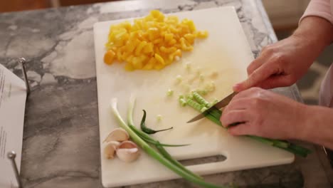 Mujer-Cortando-Cebollas-Verdes-En-Una-Tabla-De-Cortar-En-Cámara-Lenta