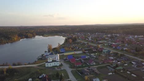 aerial view of a russian village by a lake at sunset