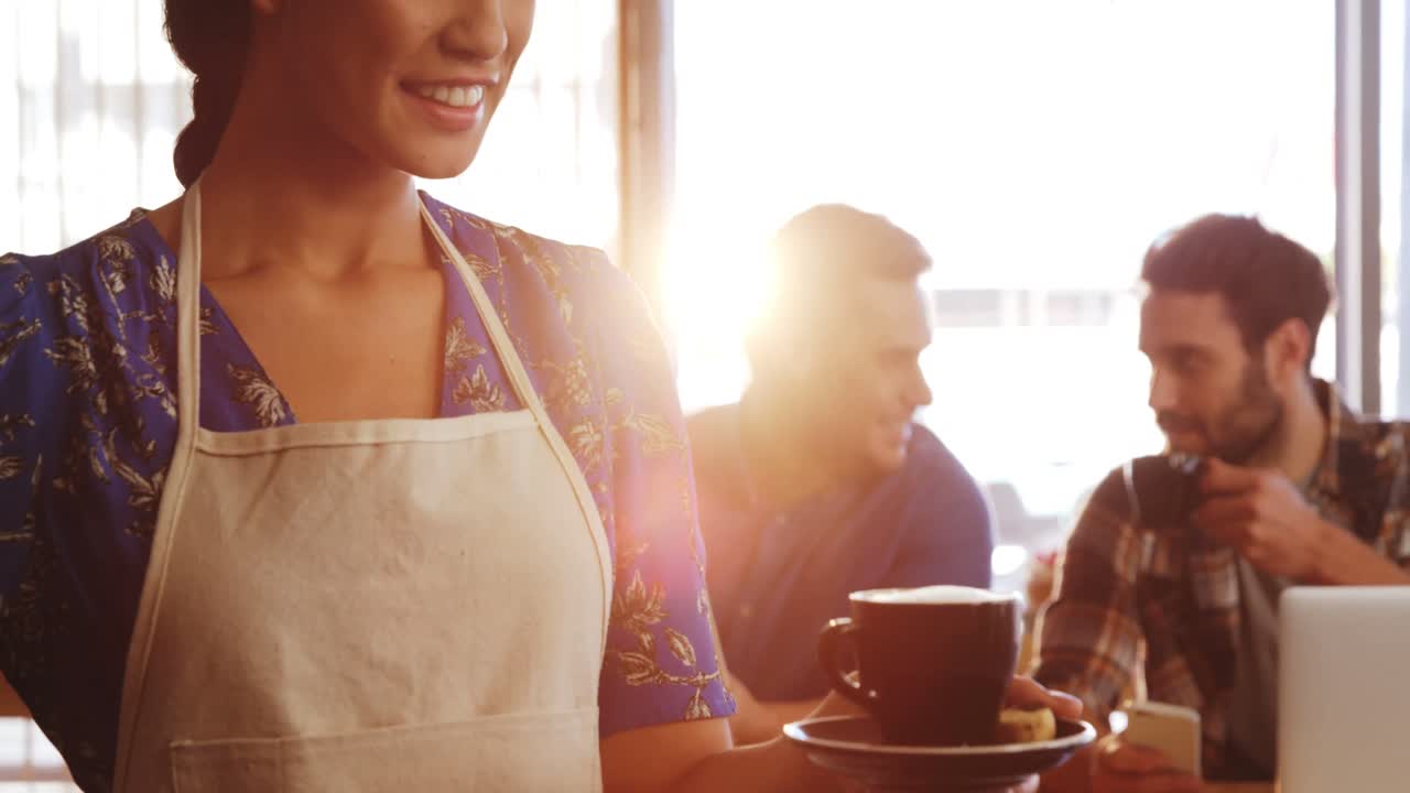 Smiling waitress with cup of coffee