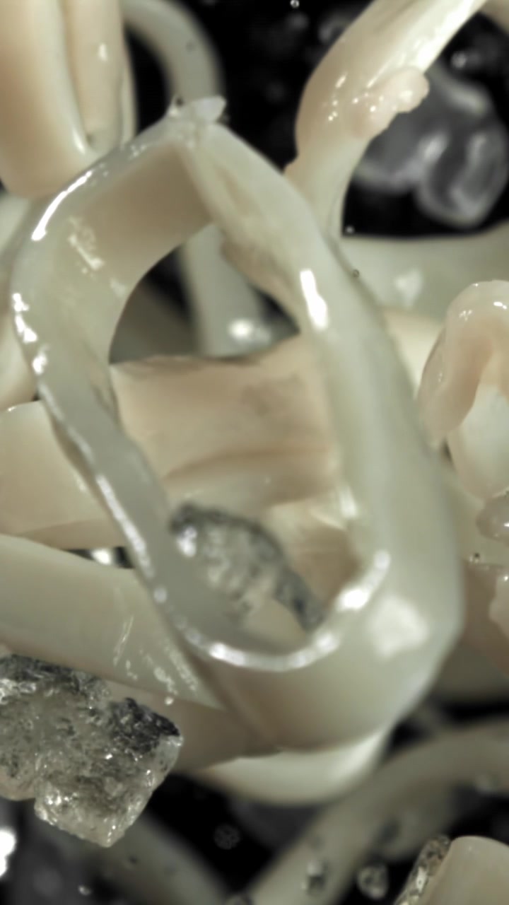 Primo piano di anelli di calamari che cadono con ghiaccio al rallentatore