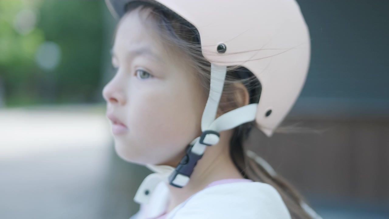 Young Girl Wearing Helmet Sitting on Bicycle in Park