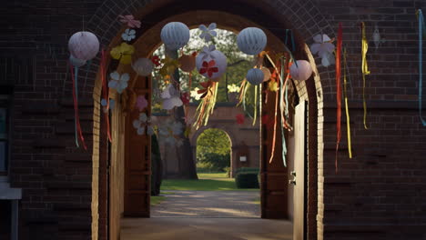 festive archway decorated with lanterns and ribbons leading to a garden