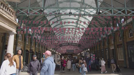 Union-Jack-Flaggen-Schmücken-Den-Covent-Garden-Market-Mit-Touristen-In-London,-Großbritannien-2