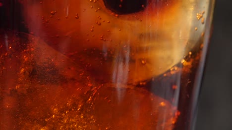 Macro-close-up-of-a-cold-drink-as-the-fizzy-bubbles-rise-around-the-ice-cubes