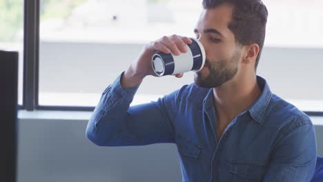 Businessman-drinking-coffee-in-modern-office