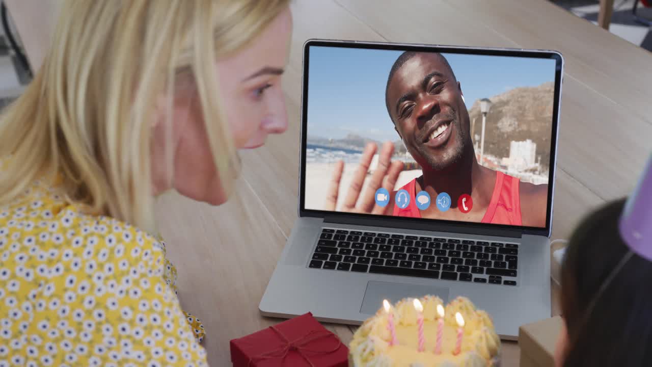 madre y hija caucásicas sentadas en la mesa usando una computadora portátil haciendo una videollamada de cumpleaños