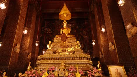 una vista serena de una estatua dorada de buda rodeada de ofrendas en wat pho, bangkok, con una cálida iluminación ambiental