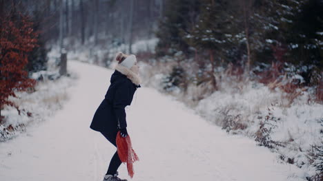 Positive-Frau,-Die-Im-Winter-Auf-Schnee-Springt-Und-Mit-Schal-Spielt