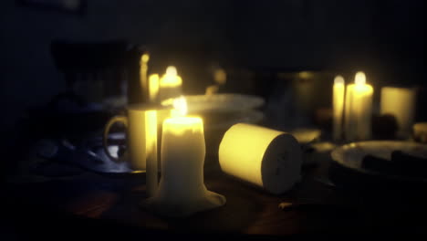 candlelight illuminated dining table with scattered dishes and warm ambiance