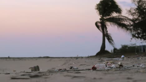 dirty tropical beach with trash, litter and plastic waste on the sand washed out by the ocean to the shore