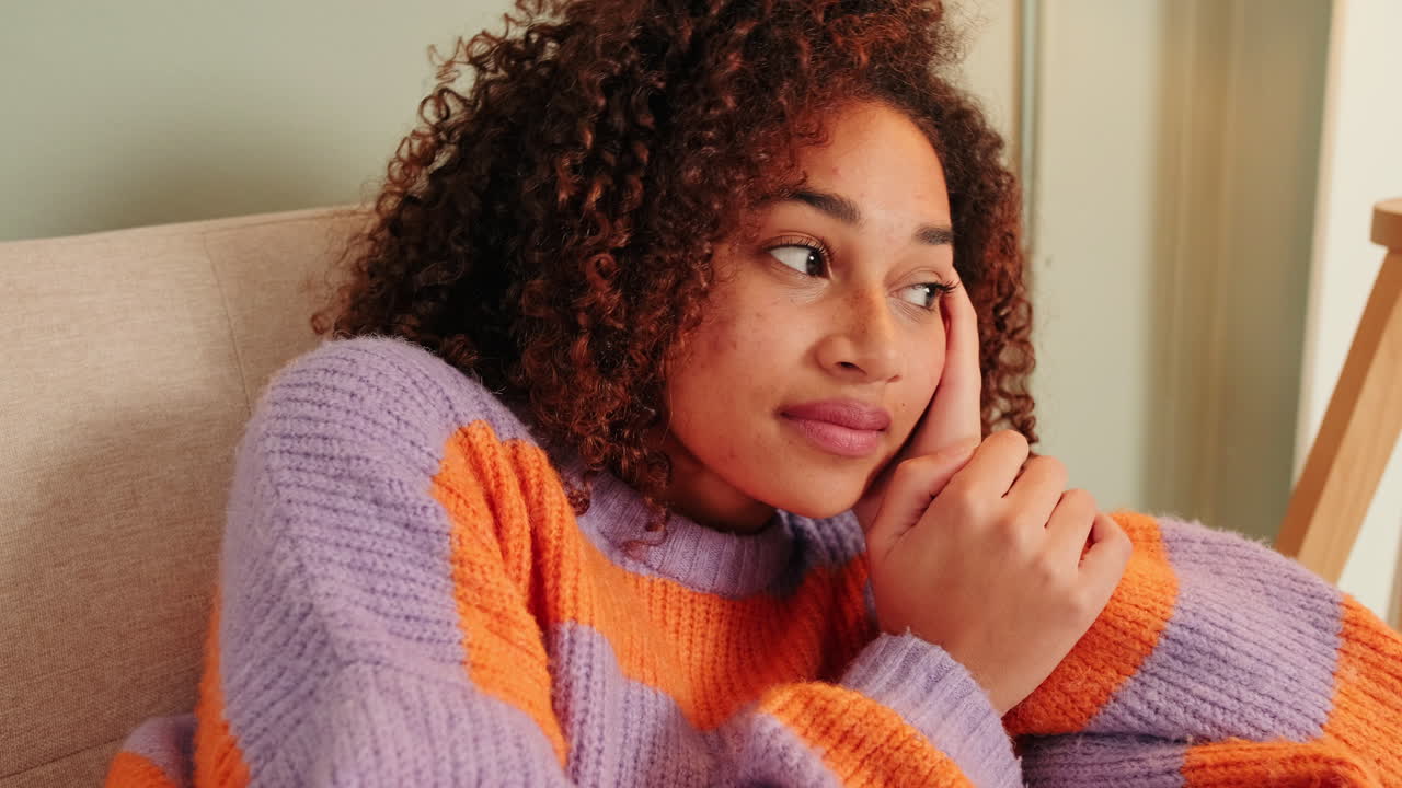 Pensive Young Woman with Curly Hair Resting Indoors