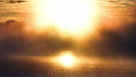 hermosa puesta de sol sobre el océano con niebla rodando por