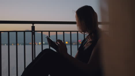 Frau-Mit-Tablet-PC-Auf-Dem-Balkon-Mit-Blick-Auf-Das-Meer