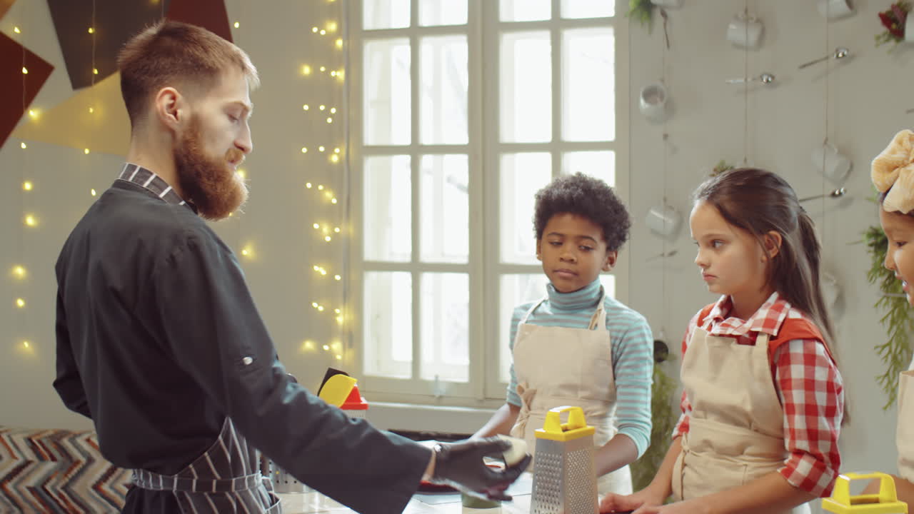 Koch gibt kleinen Kindern einen Kochmeisterkurs.