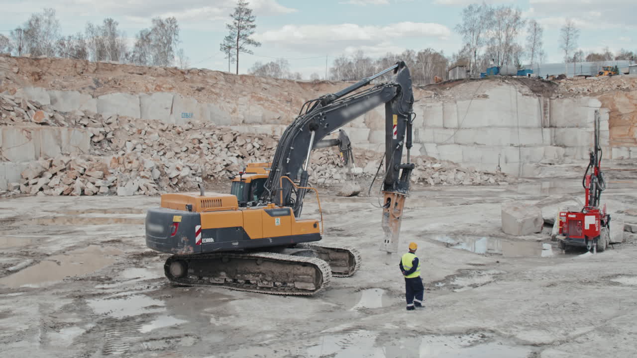 Worker and Heavy Machinery in Granite Quarry