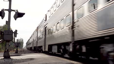 close-up-of-a-fast-commuter-train-traveling-down-rail-road-lines-4k