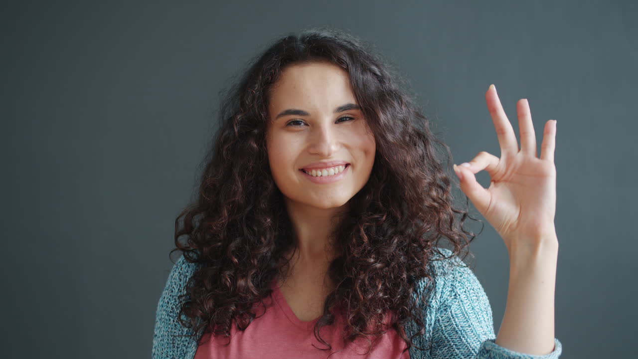 Woman smiling and making an ok sign