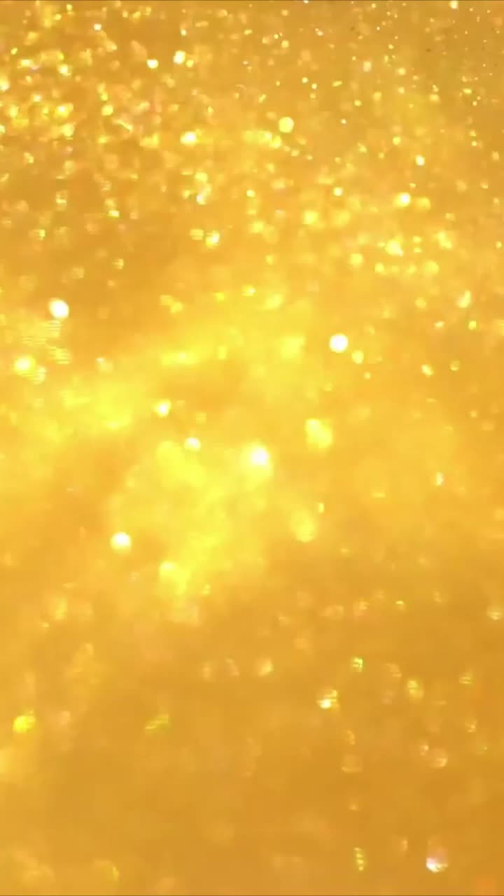 Partículas de purpurina dorada brillante con efecto bokeh.