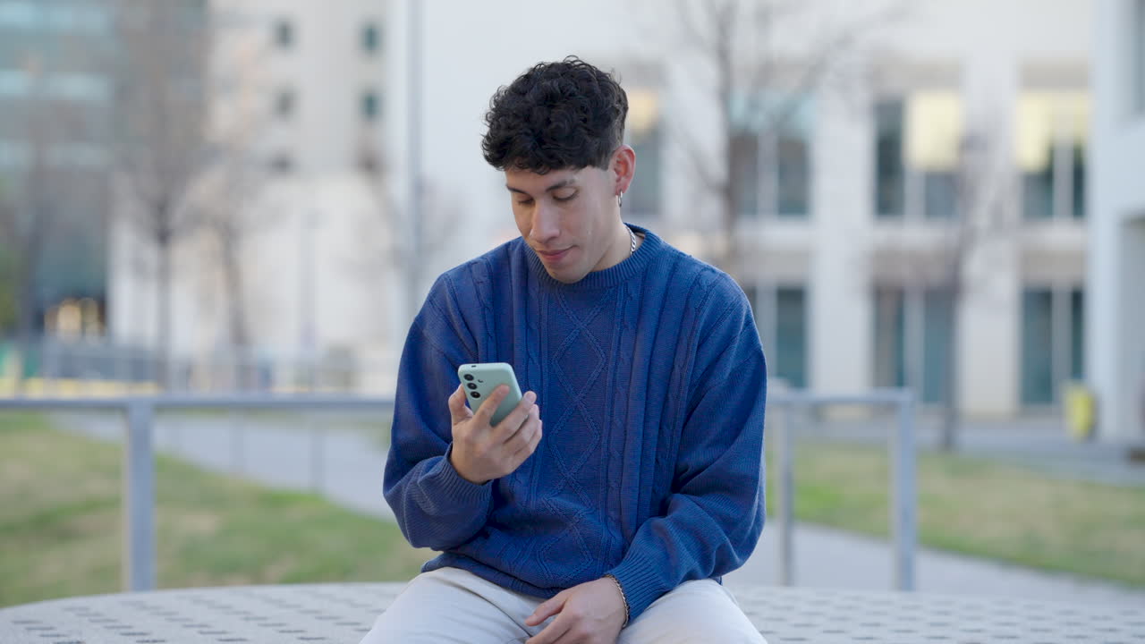 Young man expressing different emotions while using smartphone