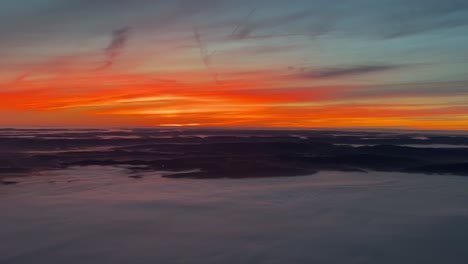 exclusive aerial view from a jet cockpit flyigh southward over germany at 8000m high at dawn with an intense red sky