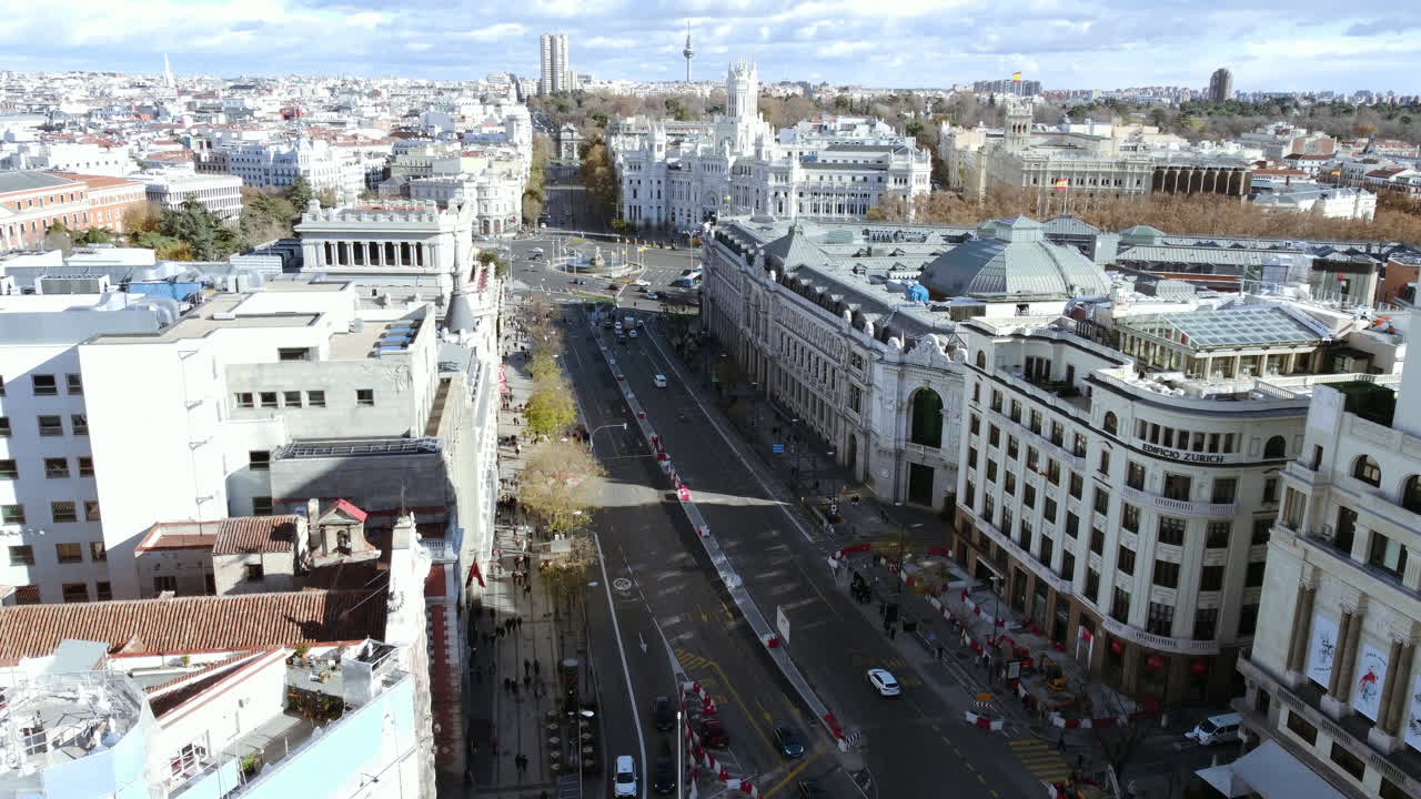 Flying over the dome of Metropolis Building and copter moving along Calle de Alcala leading to Cibeles Square with Town Hall. Madrid aerial cityscape, Spain