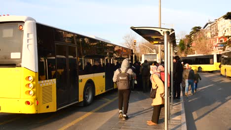 people waiting for a bus at a busy bus stop