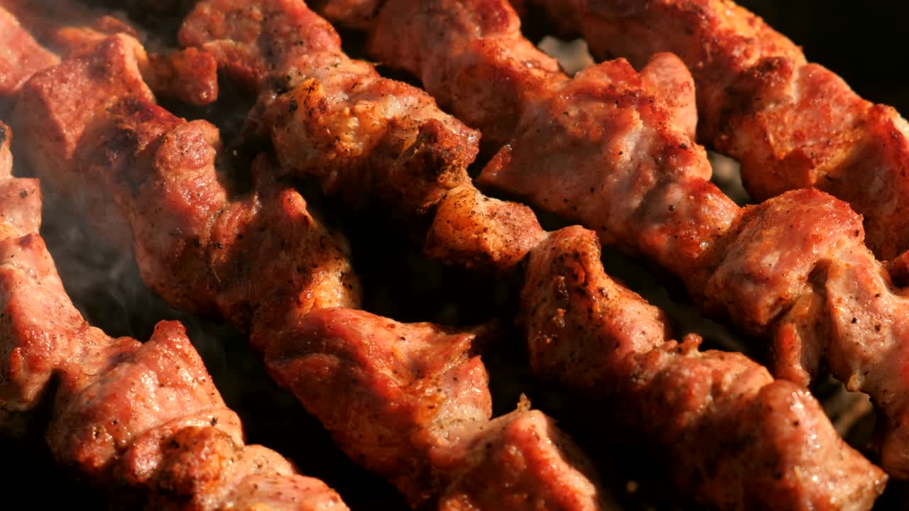 la apetecible y jugosa barbacoa de cerdo se asada en salchichas encima de la parrilla de carbón. piezas de carne de primer plano.